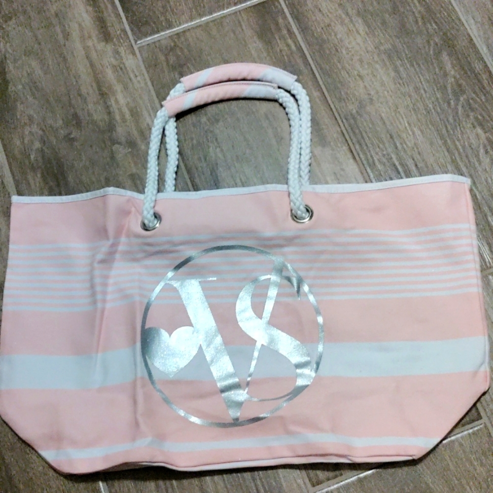 Pink and white canvas bag with silver metallic VS LOGO next to a heart